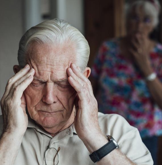 Woman looking at man holding his head