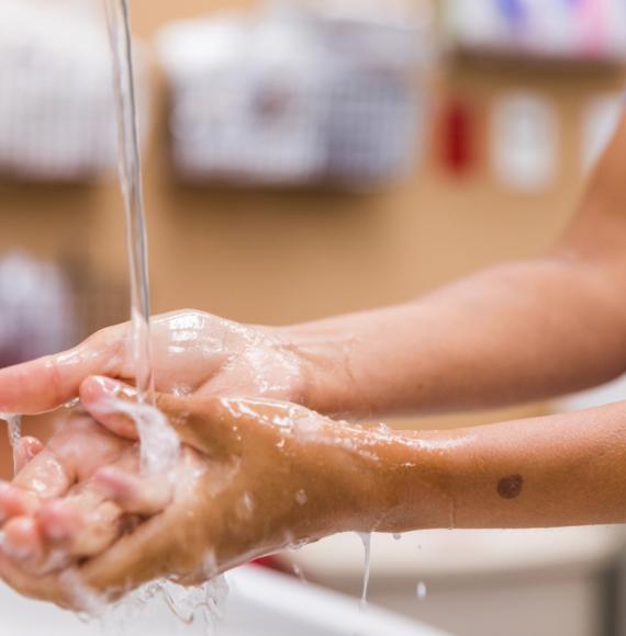 Healthcare worker washing their hands with water