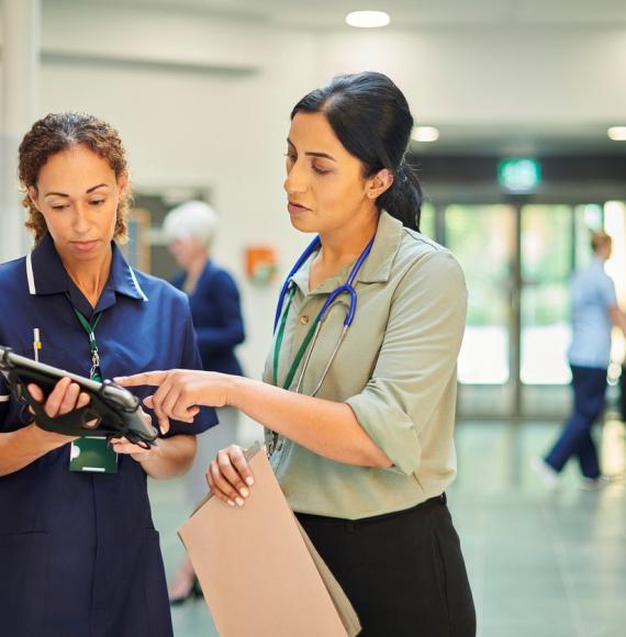 Health professionals analysing medical records on digital tablet