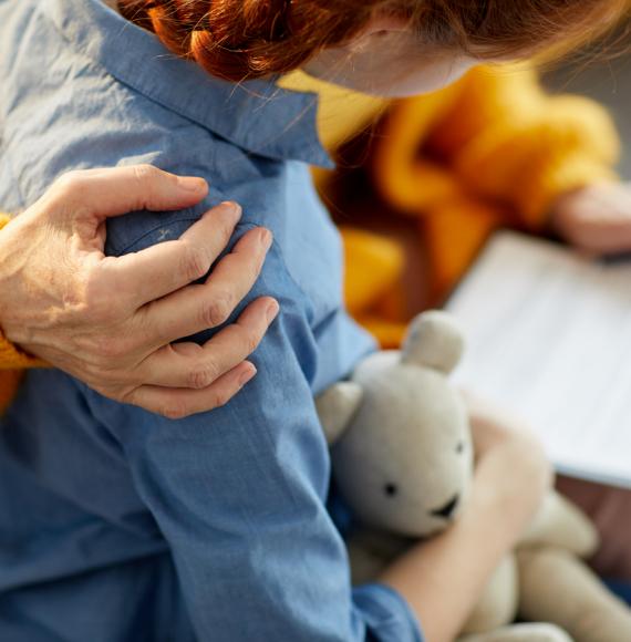 Adult's arm over the shoulder of a child