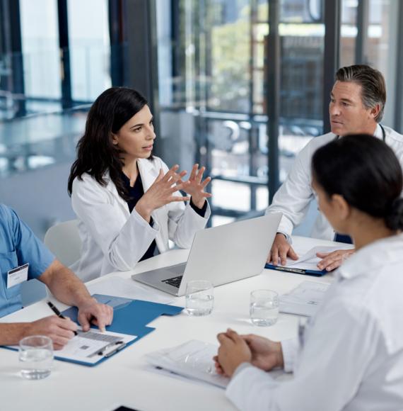 Healthcare professionals sat around a table having a meeting