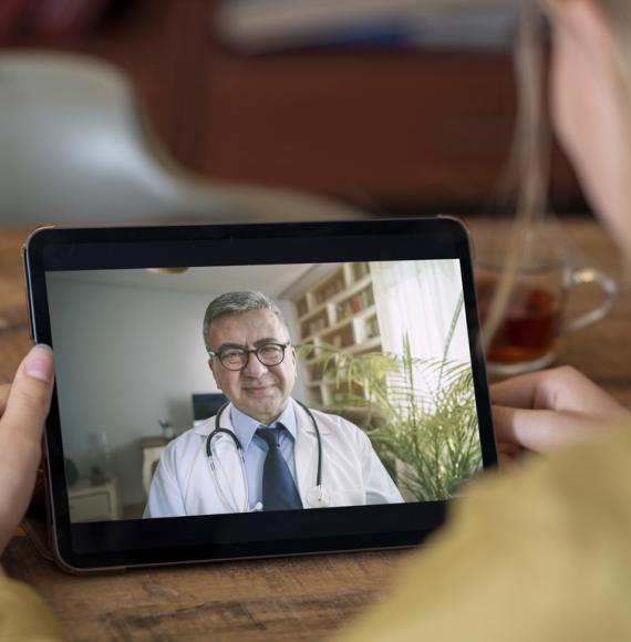 Doctor and patient talking on video call using digital tablet