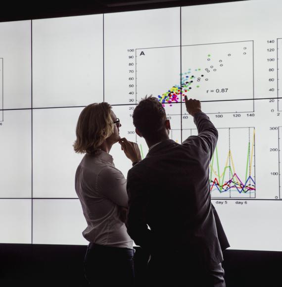 Men Viewing a Large Screen of Information