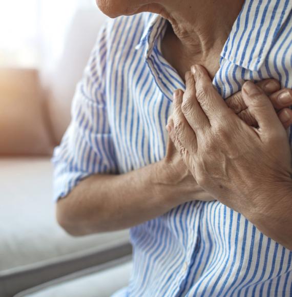 Man holding chest with heart condition
