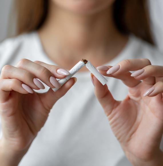 Woman breaking a cigarette in half