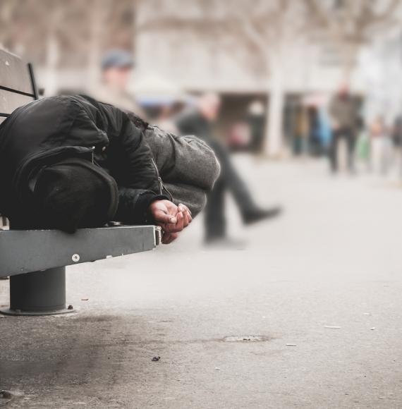 Homeless man sleeping on bench