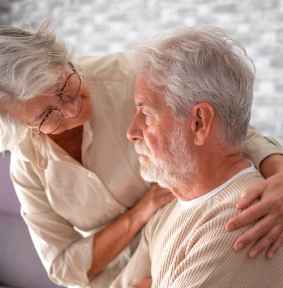 Elderly lady comforting her husband