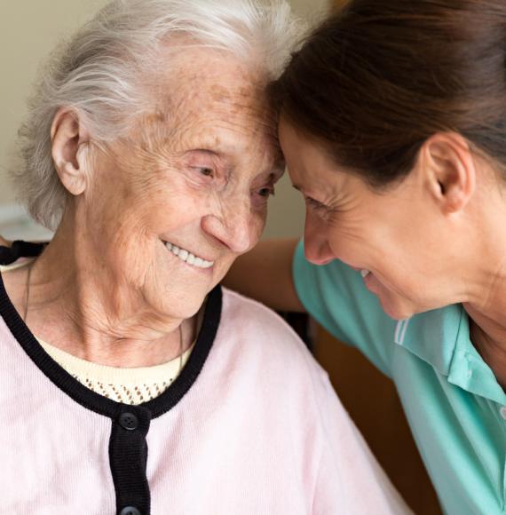 Home care giver comforting elderly patient