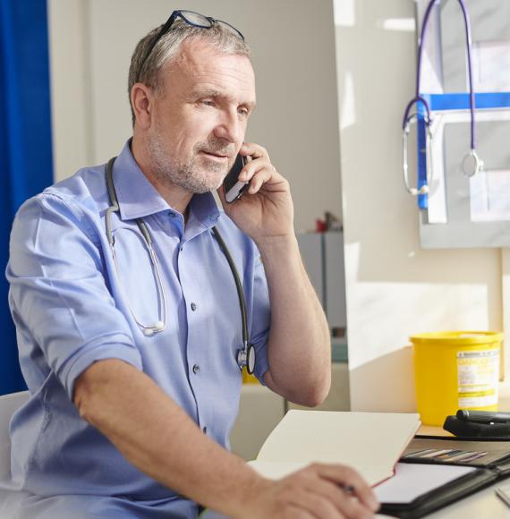 Doctor on the phone depicting new digital transformation upgrade for GP practices