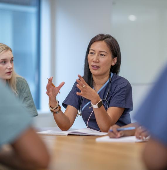 Healthcare professionals sat around a table having a meeting