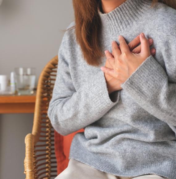 Woman clutching the left side of her chest