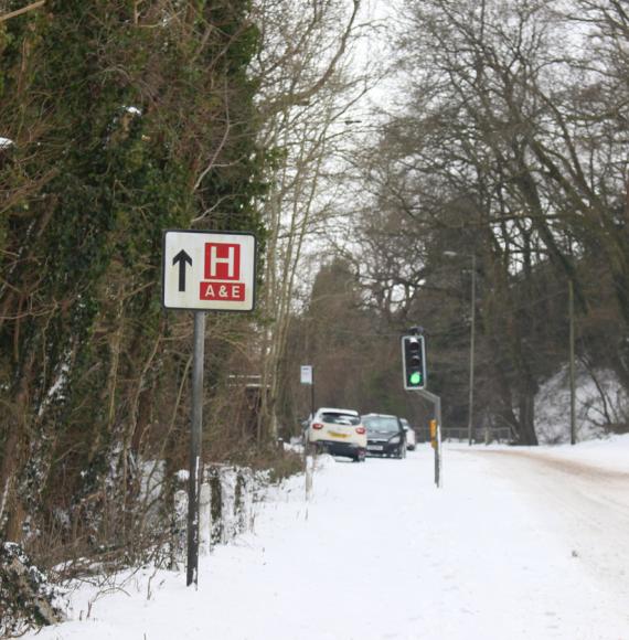 Hospital sign on a snowy road depicting NHS winter pressures