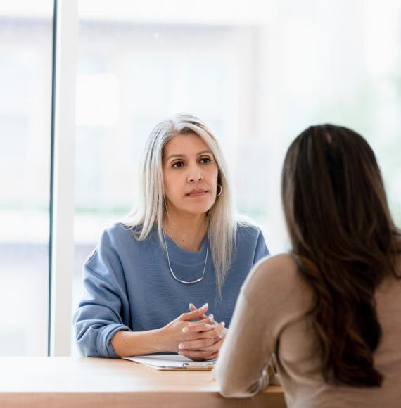 Woman talking to a serious businesswoman depicting how endometriosis affects people in the workplace and women's health