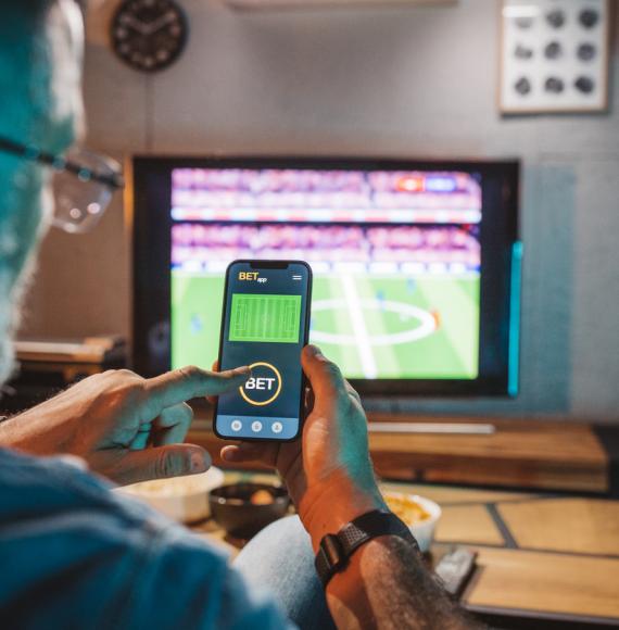 Man gambling on a football game on his phone