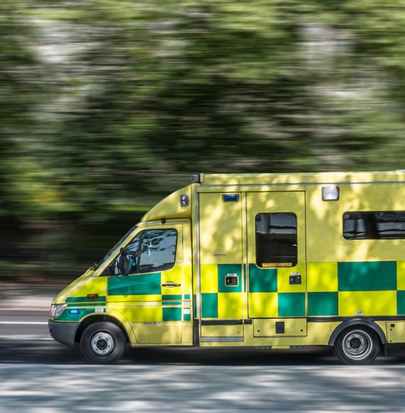 Image of an ambulance on the road depicting the NHS mobile liver cancer testing trucks