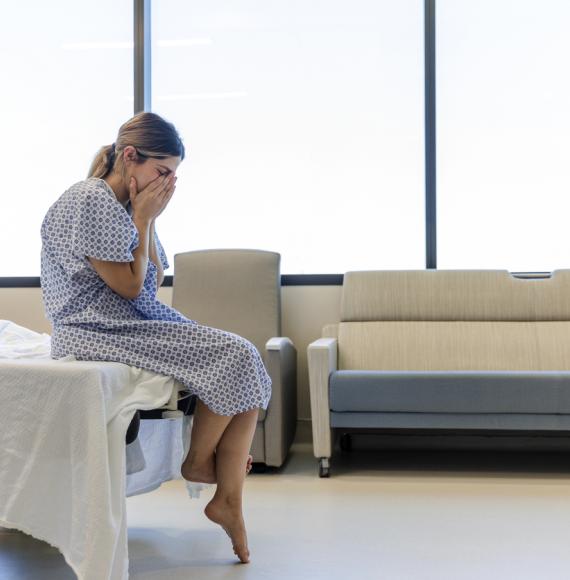 Patient sitting on a hospital bed depicting the NHS mental health crisis