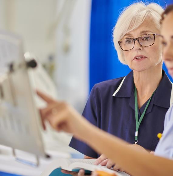 Image of two healthcare professionals working on a ward depicting NHS staff returning to work after retirement