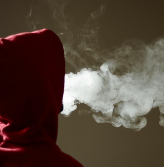 Image of a hooded figure smoking an e-cigarette depicting the UK government's youth vaping public consultation