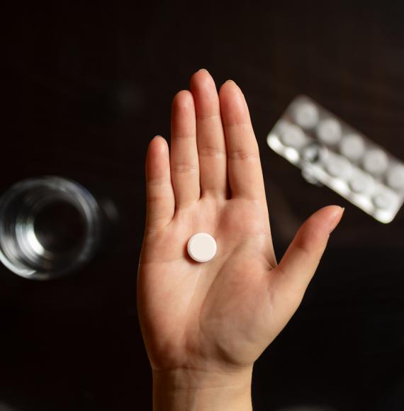 Close-up of hand holding a pill