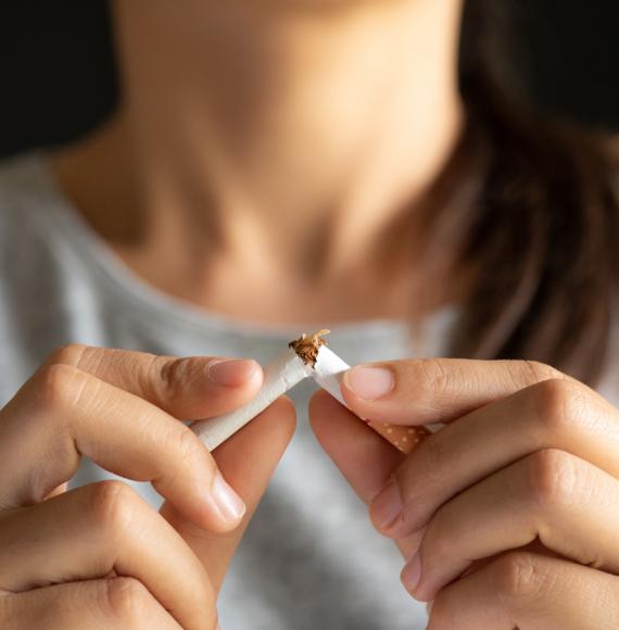 Woman breaking a cigarette in half depicting the government's stop smoking policy