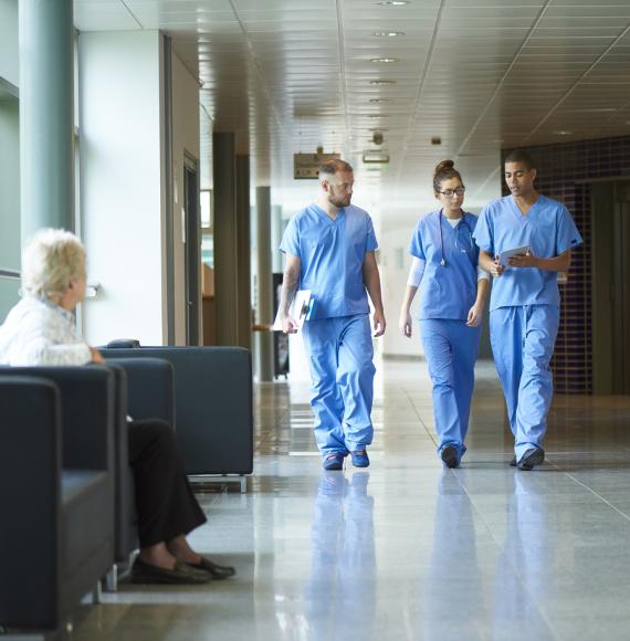 three junior doctors walking along a hospital corridor