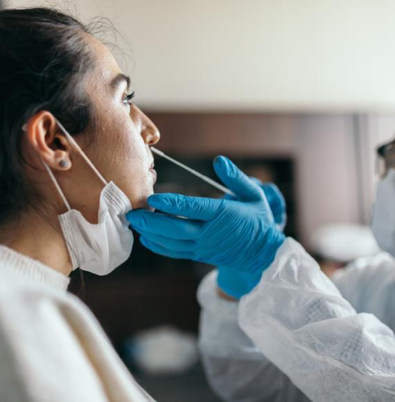 Doctor in protective workwear taking nose swab test