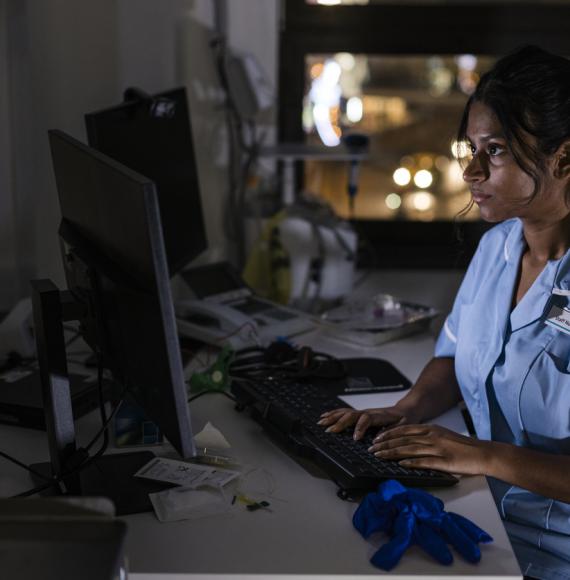 Side view of a nurse using a computer