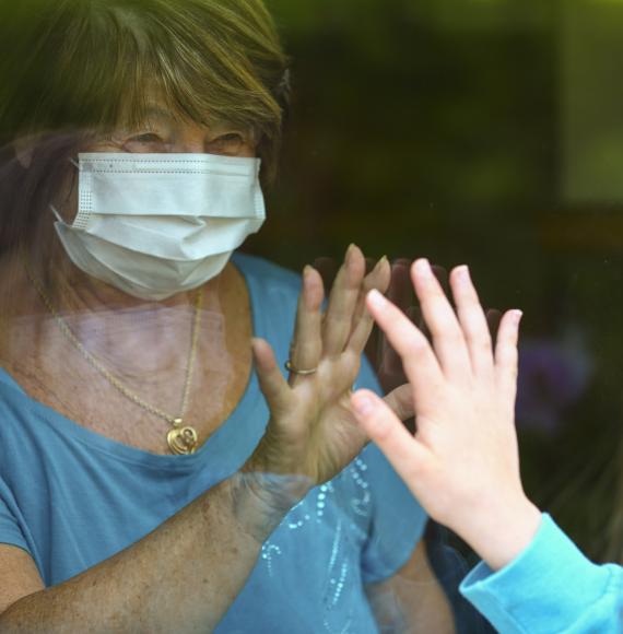 Elderly woman being visited by family during a pandemic