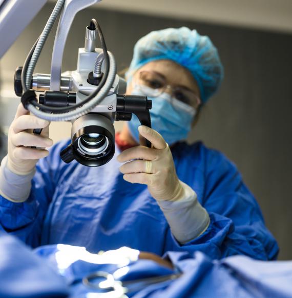 Female doctor positioning microscope