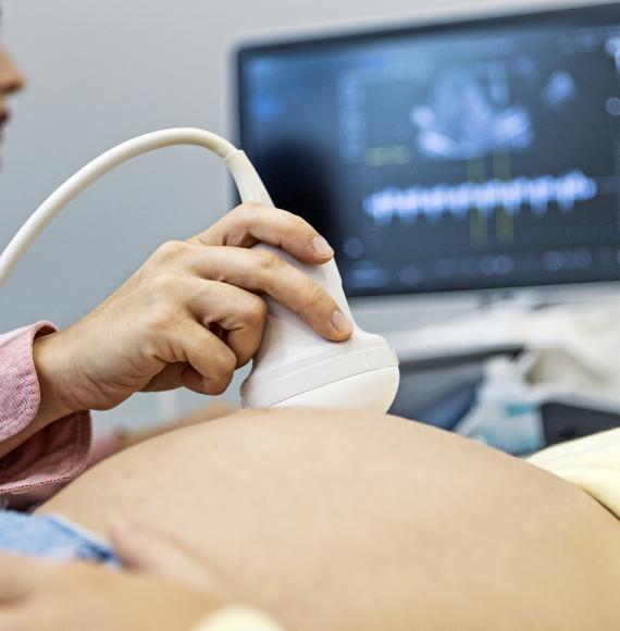 doctor performing ultrasound on a pregnant woman