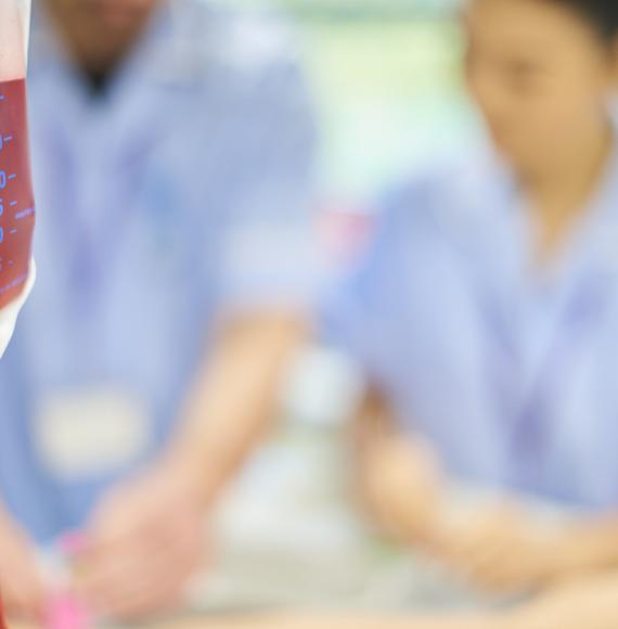A blood bag with nurses in the background