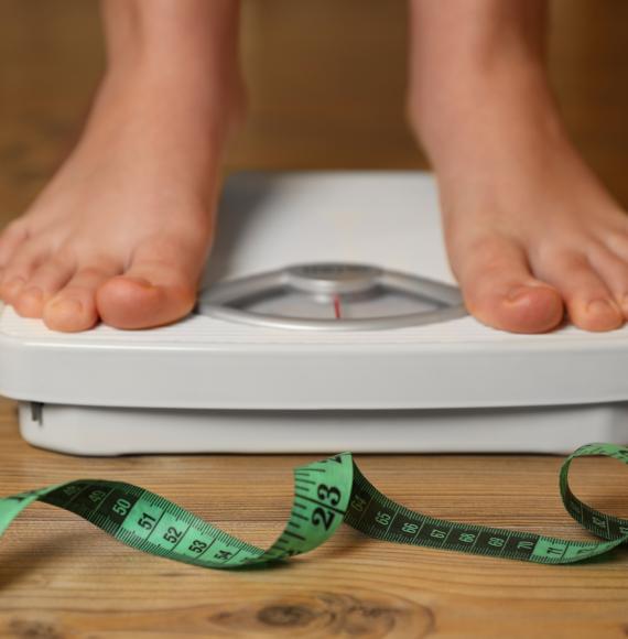 Overweight person using scales