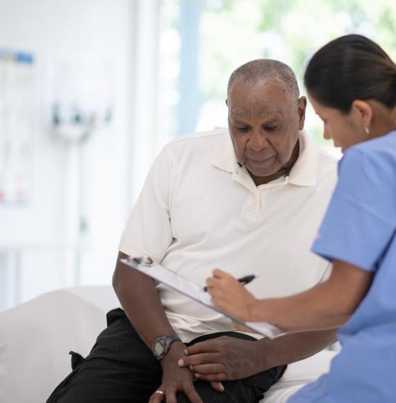 An older gentleman talks to a nurse about prostate cancer