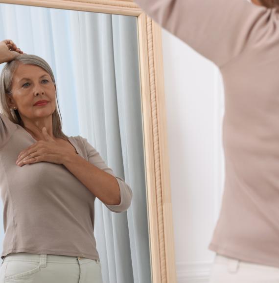 Senior woman checking for breast cancer