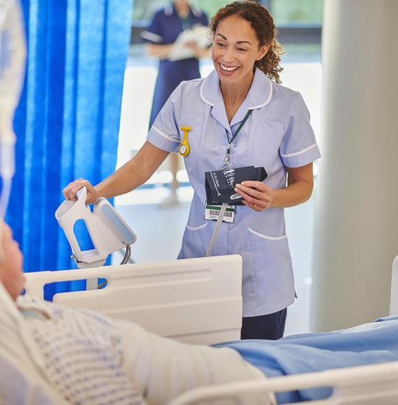 nurse chatting to patient on hospital ward