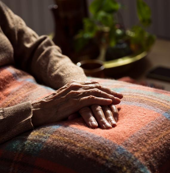 Senior woman sat under a blanket