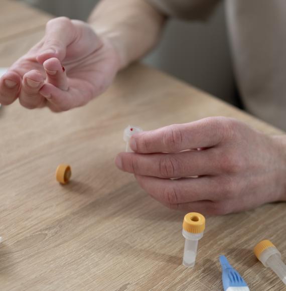 Man undertaking a finger-prick blood test