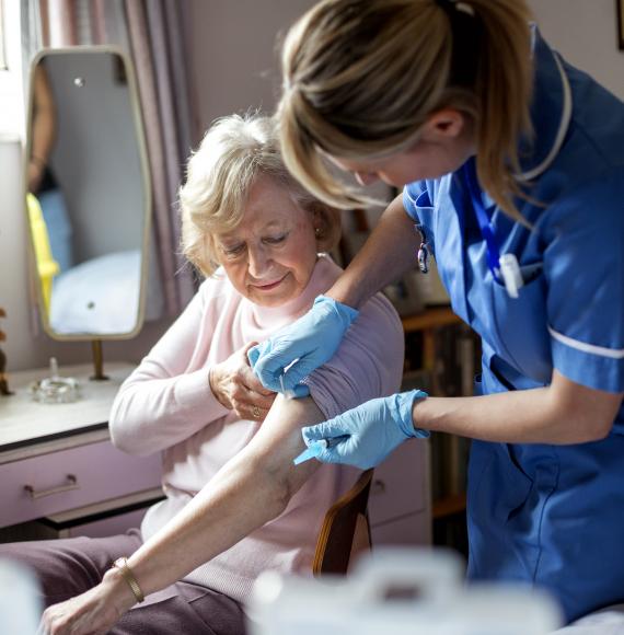 Elderly woman being vaccinated