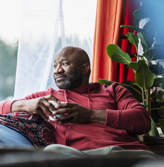 A black man sat on a sofa